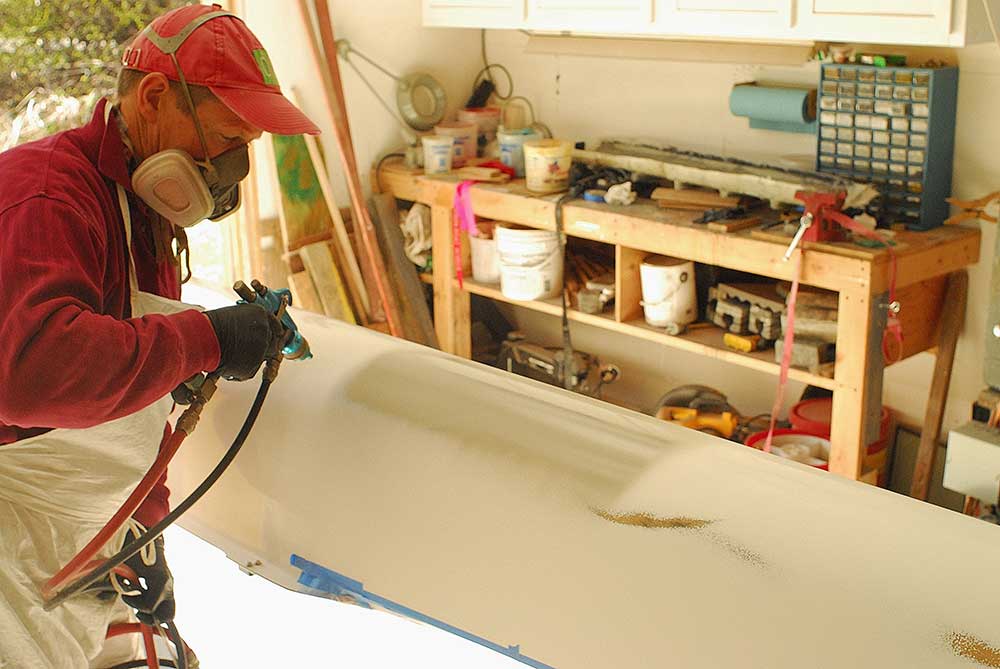Bob Gilston sanding the hull of a racing shell for small craft and rowing shell repair – from maintenance, painting and rigging to full restoration.