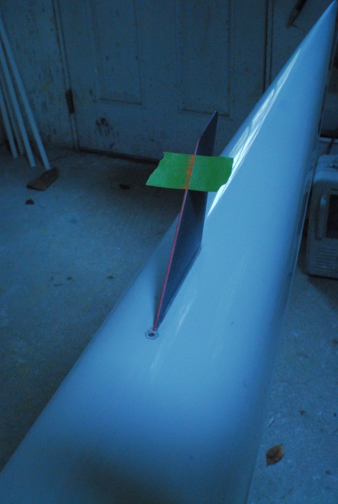 The laser line crossing the fin for laser alignment of a rowing shell fin.