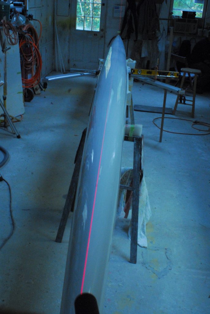 Laser fin installation of a rowing shell. The laser is following the center line for alignment of the rowing shell fin.
